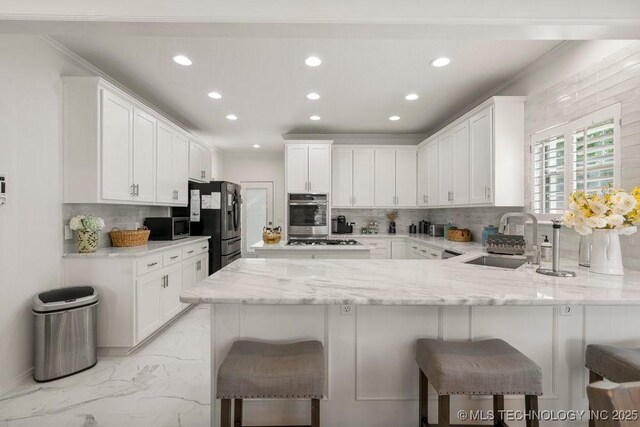9703 S 100th E Ave, Tulsa, OK 74133 - kitchen with stainless steel appliances, a peninsula, tasteful backsplash, recessed lighting, and white cabinetry