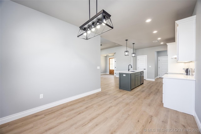 250 Maple Leaf Dr, Durant, OK 74701 - kitchen featuring recessed lighting, light countertops, white cabinetry, light wood-style floors, and an island with sink
