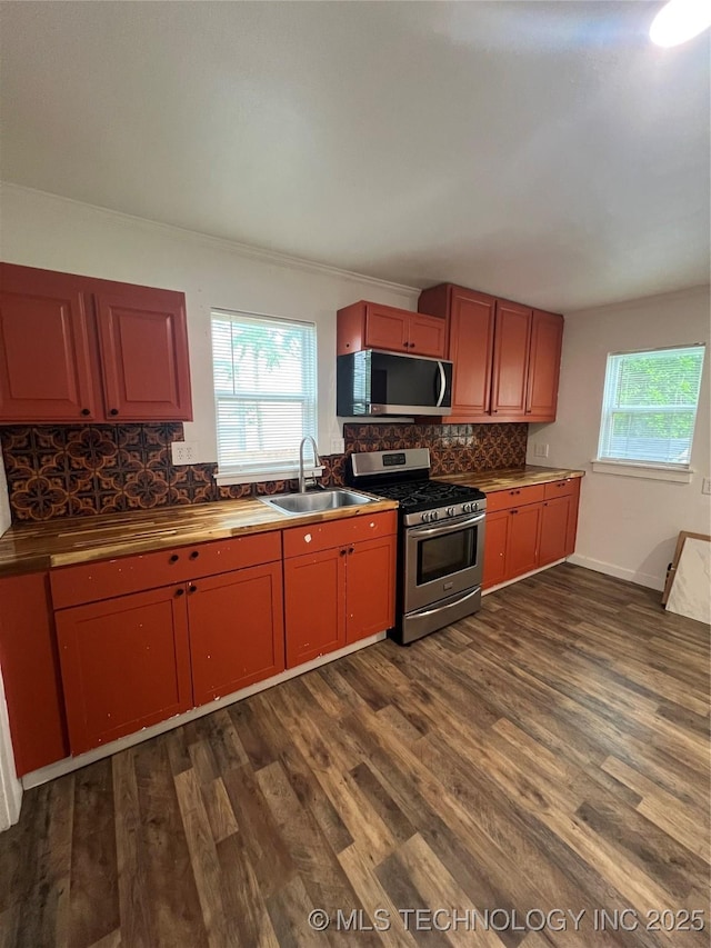 839 N New Haven Ave, Tulsa, OK 74115 - kitchen with appliances with stainless steel finishes, dark wood-type flooring, backsplash, crown molding, and butcher block countertops