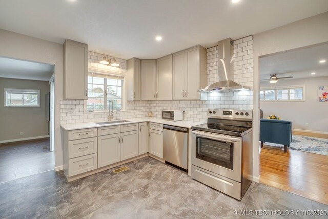 2441 S Norwood Ave, Tulsa, OK 74114 - kitchen featuring appliances with stainless steel finishes, wall chimney range hood, backsplash, light countertops, and healthy amount of natural light