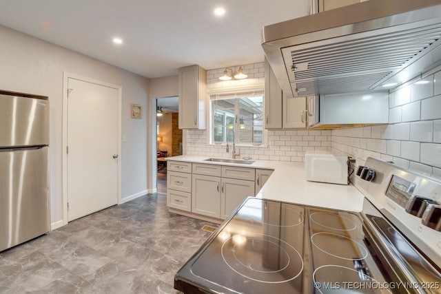 2441 S Norwood Ave, Tulsa, OK 74114 - kitchen featuring appliances with stainless steel finishes, extractor fan, tasteful backsplash, light countertops, and recessed lighting