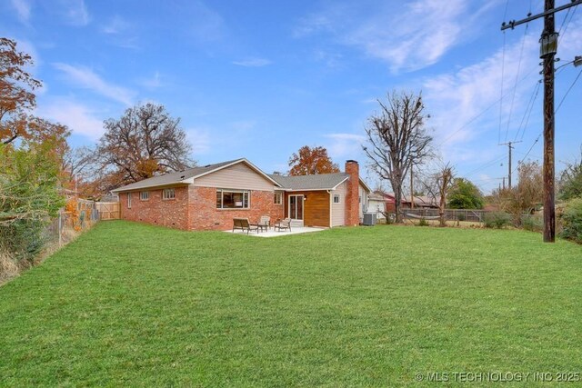 2441 S Norwood Ave, Tulsa, OK 74114 - rear view of house with a chimney, a patio area, brick siding, and a fenced backyard