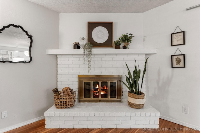 4504 S Cedar Ave, Broken Arrow, OK 74011 - detailed view of a brick fireplace, a textured ceiling, and wood finished floors