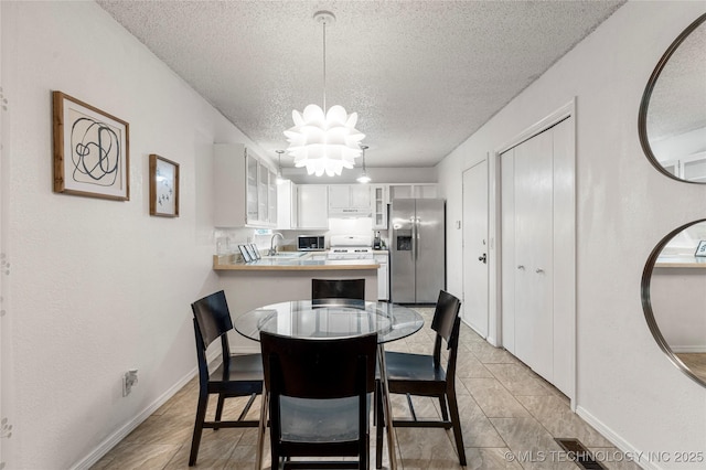 4504 S Cedar Ave, Broken Arrow, OK 74011 - dining area with a textured ceiling and a chandelier