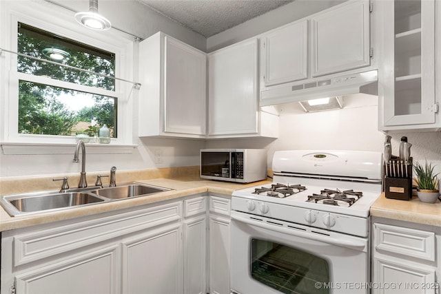 4504 S Cedar Ave, Broken Arrow, OK 74011 - kitchen with gas range gas stove, under cabinet range hood, stainless steel microwave, white cabinetry, and a textured ceiling