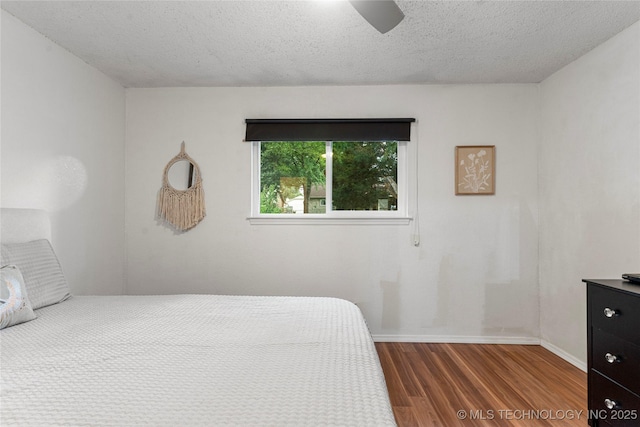 4504 S Cedar Ave, Broken Arrow, OK 74011 - bedroom with dark wood-style floors, a textured ceiling, and ceiling fan