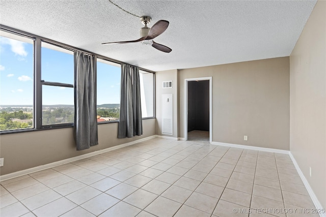 410 W 7th St Unit 1530, Tulsa, OK 74119 - unfurnished room featuring plenty of natural light, a ceiling fan, light tile patterned floors, and a textured ceiling