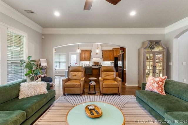 9402 E 109th St S, Tulsa, OK 74133 - living room featuring arched walkways, ornamental molding, wood finished floors, ceiling fan, and french doors