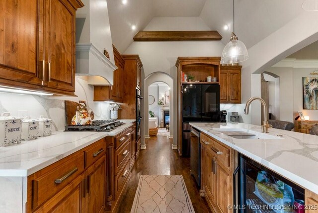 9402 E 109th St S, Tulsa, OK 74133 - kitchen featuring arched walkways, stainless steel appliances, premium range hood, dark wood-style flooring, and vaulted ceiling