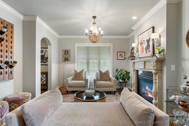 9402 E 109th St S, Tulsa, OK 74133 - living area featuring arched walkways, ornamental molding, a chandelier, and a glass covered fireplace