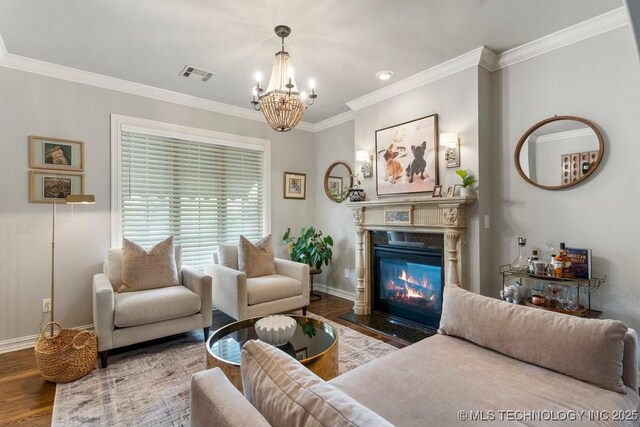 9402 E 109th St S, Tulsa, OK 74133 - living area with wood finished floors, a chandelier, a fireplace with flush hearth, and ornamental molding
