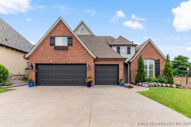9402 E 109th St S, Tulsa, OK 74133 - view of front of house with driveway, brick siding, a front yard, a shingled roof, and an attached garage