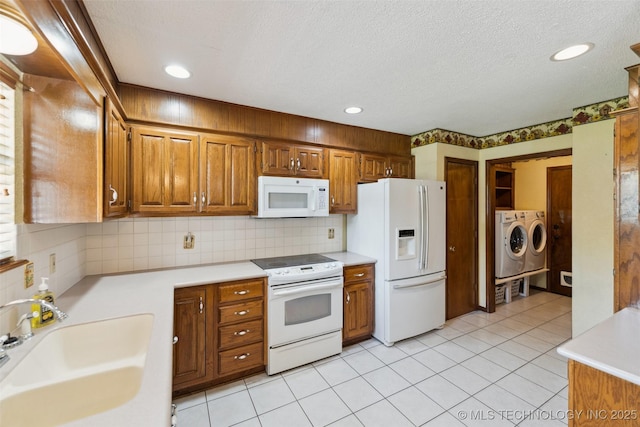 312 W Raleigh Pl, Broken Arrow, OK 74011 - kitchen with white appliances, separate washer and dryer, light countertops, brown cabinets, and recessed lighting