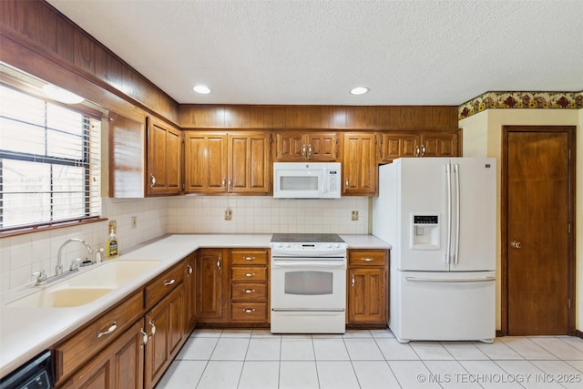 312 W Raleigh Pl, Broken Arrow, OK 74011 - kitchen featuring white appliances, brown cabinets, light countertops, a textured ceiling, and light tile patterned floors