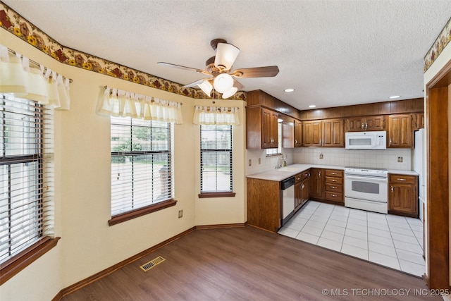 312 W Raleigh Pl, Broken Arrow, OK 74011 - kitchen with white appliances, light countertops, light wood-style floors, a textured ceiling, and brown cabinetry