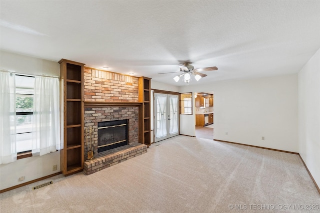 312 W Raleigh Pl, Broken Arrow, OK 74011 - unfurnished living room with plenty of natural light, carpet, a ceiling fan, and a fireplace