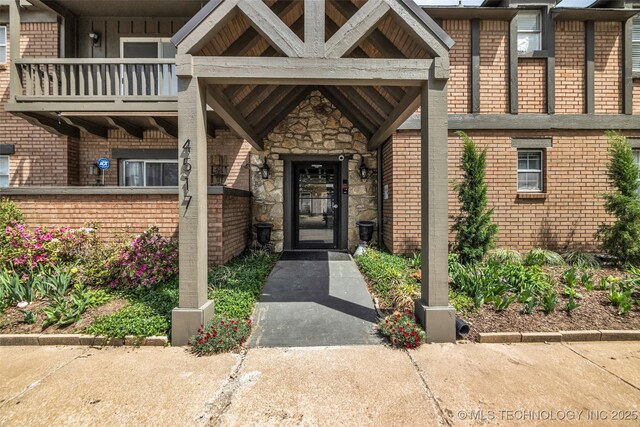 4517 S Peoria Ave Unit 31A, Tulsa, OK 74105 - view of exterior entry featuring brick siding, a balcony, and stone siding