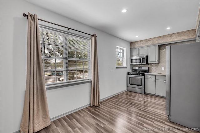 4517 S Peoria Ave Unit 31A, Tulsa, OK 74105 - kitchen featuring appliances with stainless steel finishes, light countertops, backsplash, recessed lighting, and wood finished floors