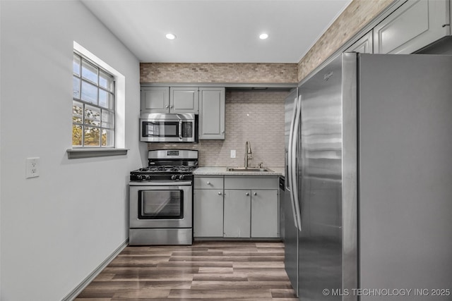 4517 S Peoria Ave Unit 31A, Tulsa, OK 74105 - kitchen with appliances with stainless steel finishes, gray cabinets, wood finished floors, backsplash, and recessed lighting