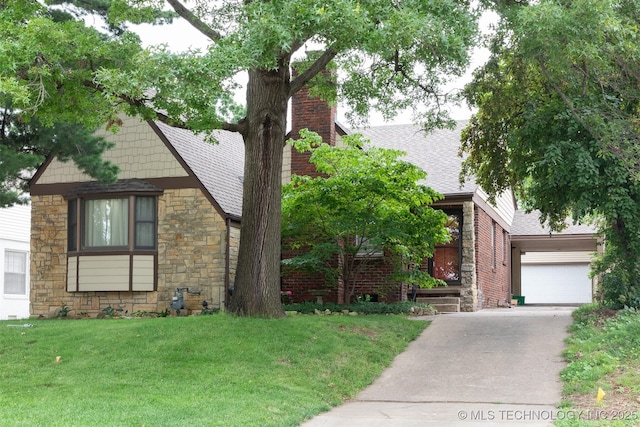 3524 E 12th Pl, Tulsa, OK 74112 - english style home with stone siding, a front yard, concrete driveway, a chimney, and roof with shingles