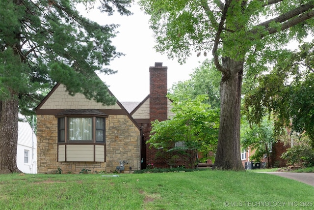 3524 E 12th Pl, Tulsa, OK 74112 - view of side of property featuring stone siding, a lawn, and a chimney