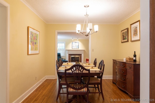 3524 E 12th Pl, Tulsa, OK 74112 - dining space featuring ornamental molding, dark wood finished floors, a chandelier, a fireplace, and a textured ceiling