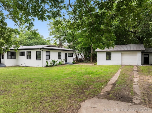 575 N 7th St, Muskogee, OK 74401 - view of green lawn with driveway, an attached garage, and an outbuilding