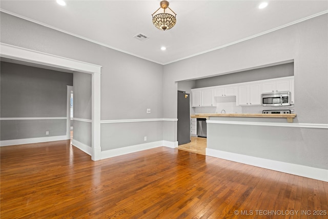 575 N 7th St, Muskogee, OK 74401 - unfurnished living room featuring hardwood / wood-style flooring, ornamental molding, and recessed lighting