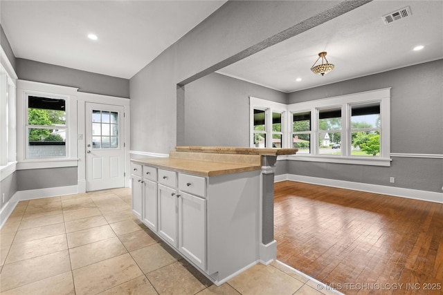 575 N 7th St, Muskogee, OK 74401 - kitchen with healthy amount of natural light, white cabinetry, recessed lighting, light tile patterned flooring, and butcher block countertops