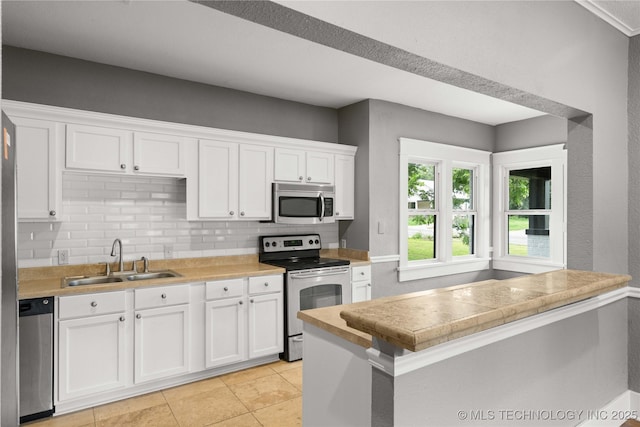 575 N 7th St, Muskogee, OK 74401 - kitchen with stainless steel appliances, backsplash, white cabinetry, light countertops, and light tile patterned flooring