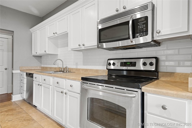575 N 7th St, Muskogee, OK 74401 - kitchen with appliances with stainless steel finishes, white cabinets, light countertops, and backsplash