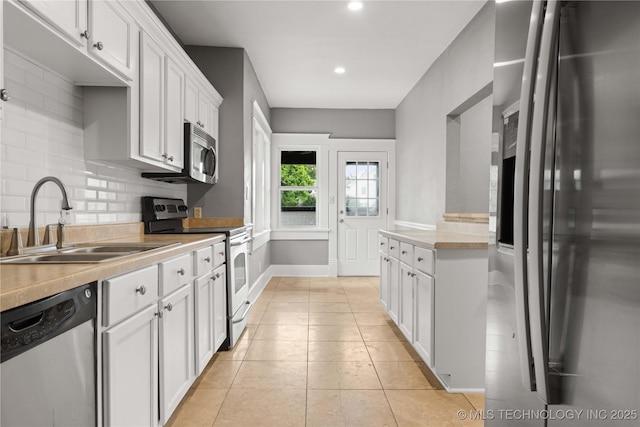 575 N 7th St, Muskogee, OK 74401 - kitchen featuring stainless steel appliances, white cabinets, backsplash, recessed lighting, and light countertops