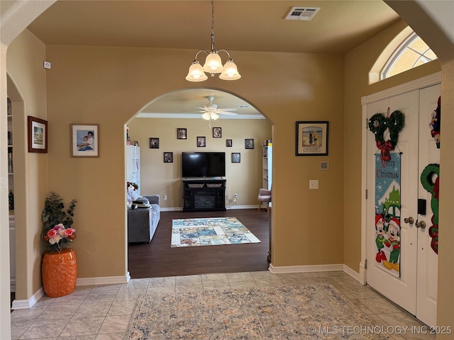 607 Nelson, Mcalester, OK 74501 - entrance foyer featuring arched walkways, a ceiling fan, crown molding, and a chandelier