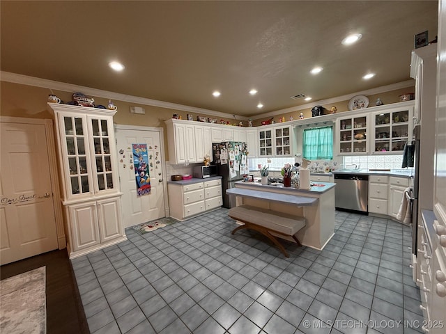 607 Nelson, Mcalester, OK 74501 - kitchen with stainless steel appliances, ornamental molding, tile patterned flooring, white cabinets, and a center island