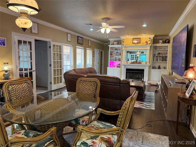607 Nelson, Mcalester, OK 74501 - dining space featuring ceiling fan, wood finished floors, ornamental molding, a glass covered fireplace, and recessed lighting