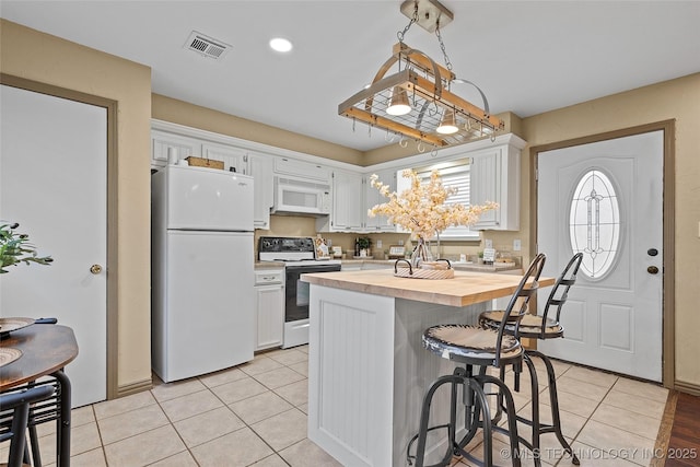 1604 9th Ave NW, Ardmore, OK 73401 - kitchen featuring white appliances, butcher block counters, white cabinetry, and a kitchen breakfast bar