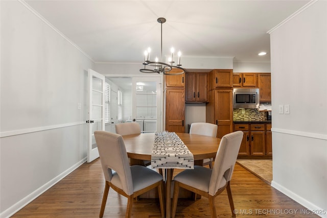 5914 E 26th St, Tulsa, OK 74114 - dining space featuring washing machine and dryer, a chandelier, ornamental molding, wood finished floors, and recessed lighting
