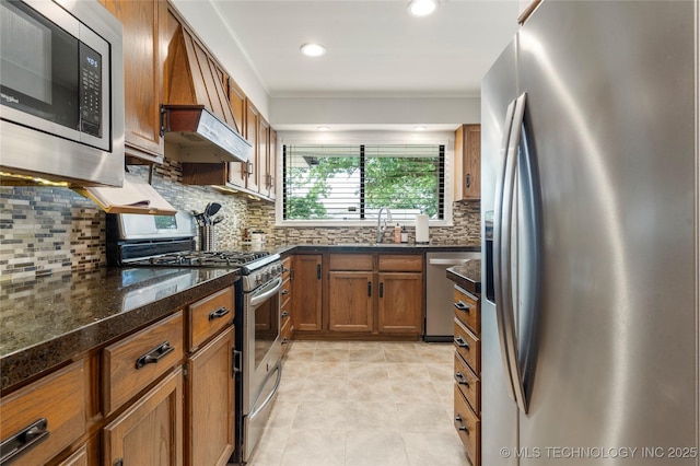 5914 E 26th St, Tulsa, OK 74114 - kitchen with appliances with stainless steel finishes, brown cabinetry, decorative backsplash, dark stone counters, and recessed lighting