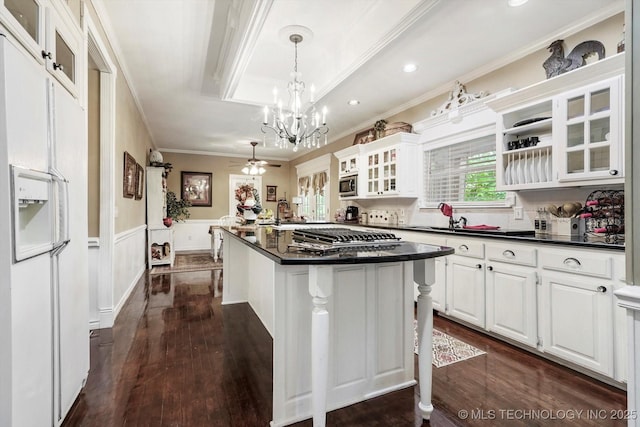 1110 N Renaissance Dr, Sand Springs, OK 74063 - kitchen featuring appliances with stainless steel finishes, crown molding, dark countertops, dark wood-type flooring, and white cabinetry