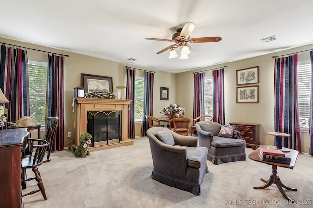1110 N Renaissance Dr, Sand Springs, OK 74063 - carpeted living room featuring a fireplace with raised hearth, plenty of natural light, and a ceiling fan