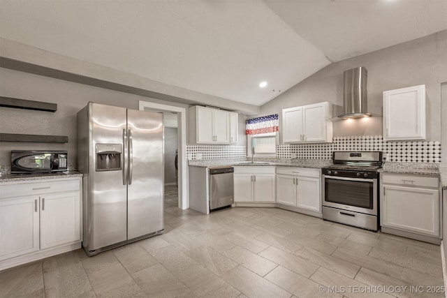 705 W Center St, Collinsville, OK 74021 - kitchen with appliances with stainless steel finishes, wall chimney exhaust hood, vaulted ceiling, backsplash, and white cabinets