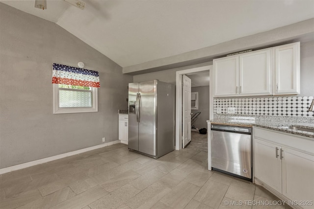 705 W Center St, Collinsville, OK 74021 - kitchen featuring appliances with stainless steel finishes, vaulted ceiling, white cabinets, decorative backsplash, and light stone counters