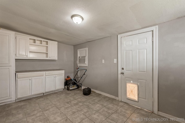 705 W Center St, Collinsville, OK 74021 - kitchen featuring a textured ceiling, open shelves, and white cabinetry