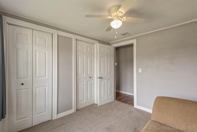 705 W Center St, Collinsville, OK 74021 - unfurnished bedroom with carpet flooring, two closets, a ceiling fan, and ornamental molding