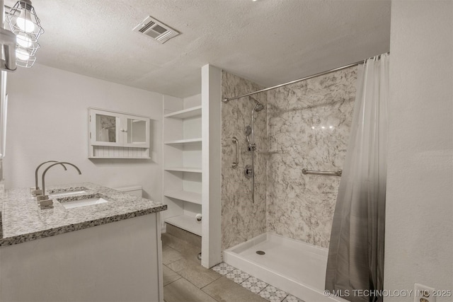 705 W Center St, Collinsville, OK 74021 - bathroom featuring a textured ceiling, a shower with shower curtain, vanity, and tile patterned floors