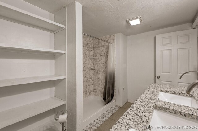 705 W Center St, Collinsville, OK 74021 - bathroom with a textured ceiling, a shower stall, and vanity