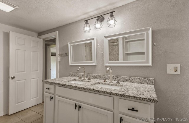 705 W Center St, Collinsville, OK 74021 - full bath featuring double vanity, a textured ceiling, tile patterned floors, and a textured wall