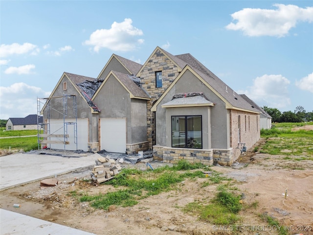 2614 E 134th Cir S, Bixby, OK 74008 - view of front of house with stone siding, stucco siding, a shingled roof, and driveway