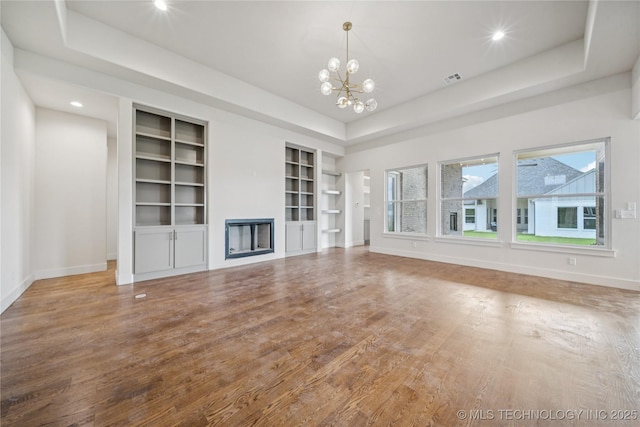 2614 E 134th Cir S, Bixby, OK 74008 - unfurnished living room with built in shelves, a chandelier, wood finished floors, a fireplace, and recessed lighting