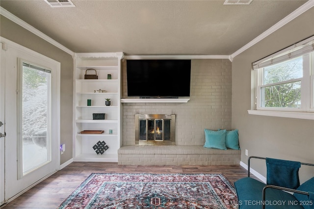 810 N 3rd St, Jenks, OK 74037 - living room with crown molding, wood finished floors, a textured ceiling, a fireplace, and built in shelves
